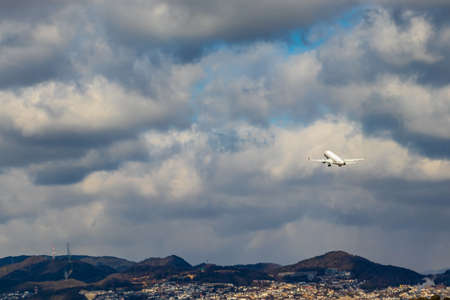 An airplane taking off toward the cloudy skyの写真素材