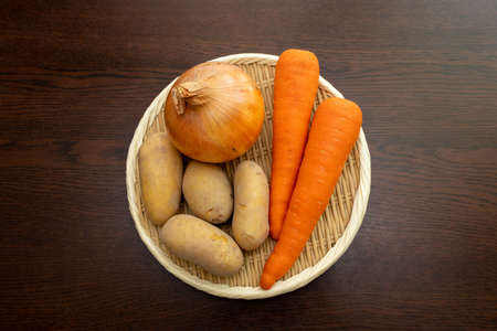 Root vegetables on a bamboo colanderの写真素材