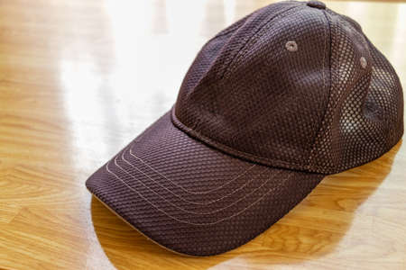 Black cap on the desk by the windowの写真素材