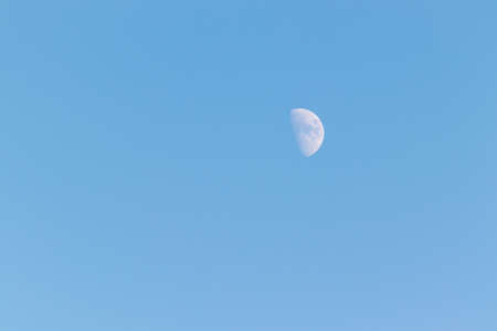 Half moon in the blue skyの写真素材