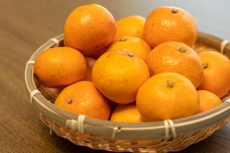 Many oranges on a bamboo colanderの写真素材