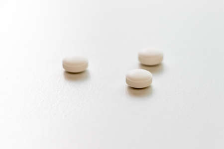 Three white tablets on the tableの写真素材
