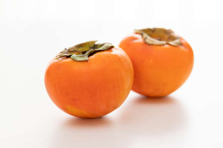 Two persimmons on white backgroundの写真素材