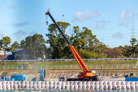 Mobile crane lifting a long steel material at construction siteの写真素材