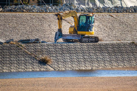 Construction machine that crushes concrete on embankment with a drill