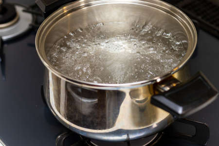 Water bubbling in a metal potの写真素材