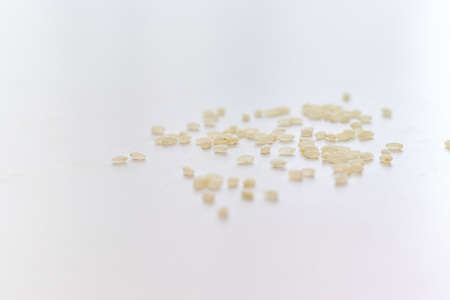 White rice grains scattered on the white tableの写真素材