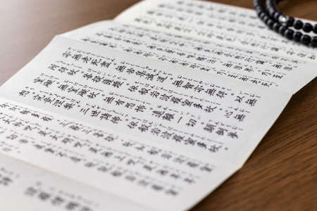 Buddhist sutra on a wooden deskの写真素材