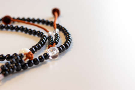 Black rosary on a white deskの写真素材