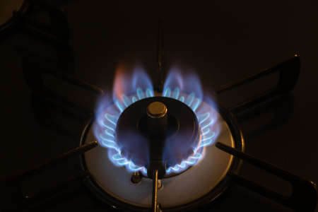 A burner that burns with red fire flickering in blue flame