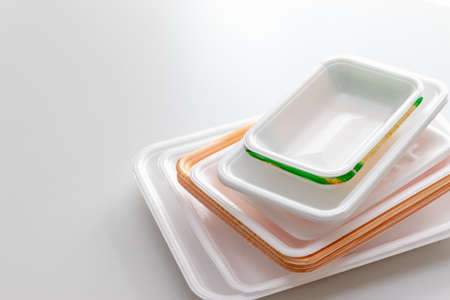 Plastic trays stacked on a white table