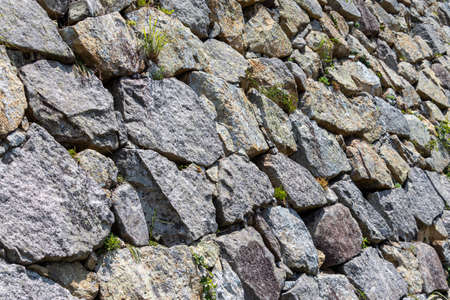 The rugged surface of the stone wall seen from an angle