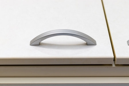Metal handle on the white door of the storage shelfの写真素材