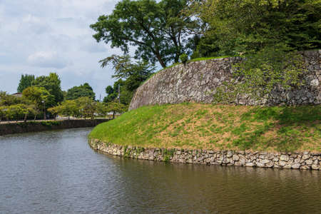 Old stone wall surrounded by the water moat in Hikone Castle