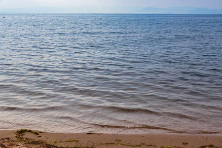 Waves gently lapping on the sandy beach in the evening