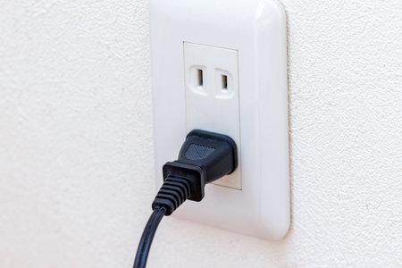 Power plug connected to wall outlet in room