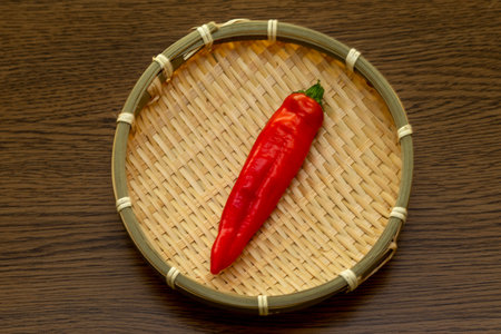 A red chili pepper on the bamboo colanderの写真素材