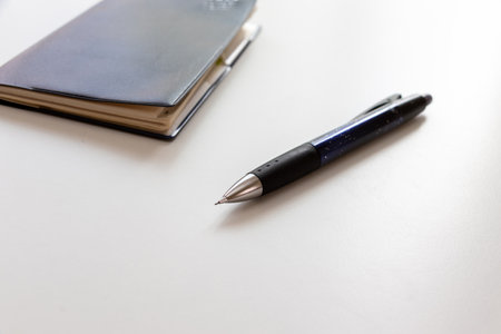 Pocket book and ballpoint pen on the white tableの写真素材
