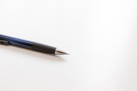 The nib of a mechanical pencil with the lead slightly protruding
