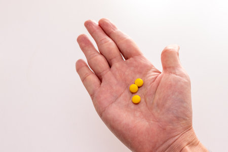 Three yellow tablets on the palmの写真素材