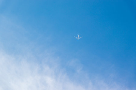A white airplane flying in the blue sky