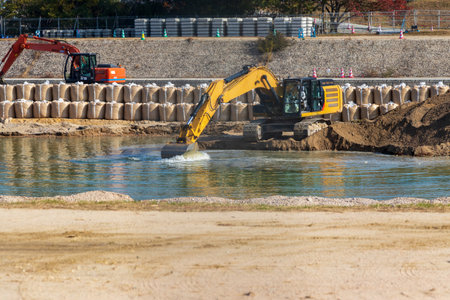 Hydraulic excavator scooping sediment from the riverbedの写真素材