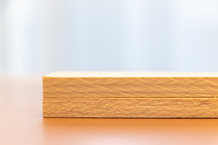 Two wooden boards stacked on top of a workbenchの写真素材