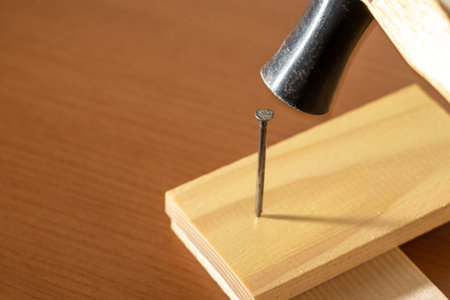 Hammer a nail into a piece of woodの写真素材