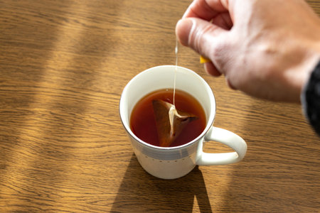 tea cup with tea bag on wooden table, close-upの写真素材