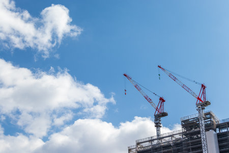 Crane and building under construction with blue sky backgroundの写真素材