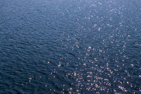 Water surface with sun reflection. Natural background and texture for design.の写真素材