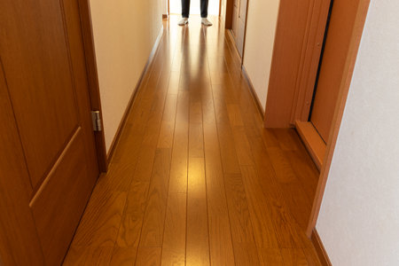 A person standing at the end of a wooden hallwayの写真素材
