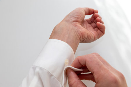 button the cuffs of a white shirt
