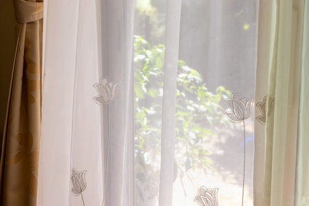 White lace curtains blocking sunlight from the windowの写真素材