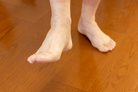 Standing on one leg on a wooden floorの写真素材