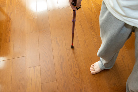 A person standing with a cane in a roomの写真素材