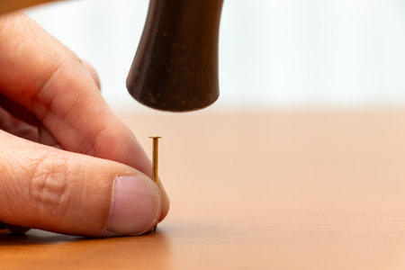 Hammer a metal pin into wood