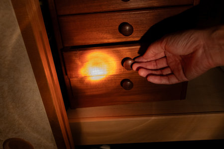Open the drawer while illuminating the chest with a flashlightの写真素材