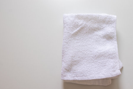 A folded white towel on a tableの写真素材