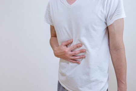 A man rubbing his stomach with his handの写真素材