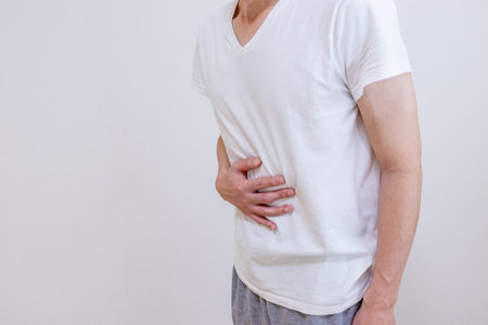 A man rubbing his stomach with his handの写真素材