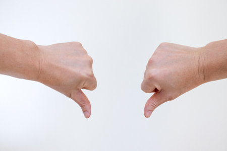 Booing hand sign with both thumbs down