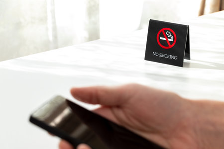 Using a smartphone at a non-smoking tableの写真素材