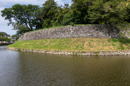 Old stone wall surrounded by the water moat in Hikone Castleの写真素材