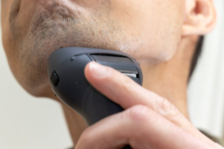 Man shaving his chin with an electric shaverの写真素材