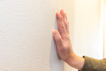 Touching the white wall with one handの写真素材