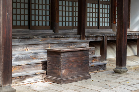 A wooden offering box placed in front of the Buddhist hall of a templeの写真素材