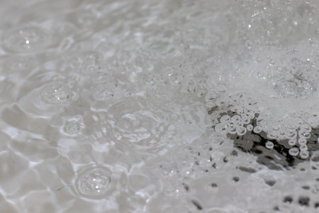 Water splashing down the sink drainの写真素材