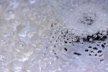 Water splashing down the sink drainの写真素材