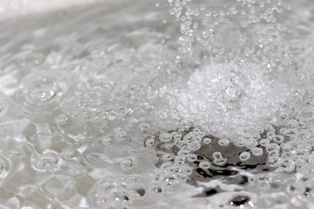 Water splashing down the sink drainの写真素材